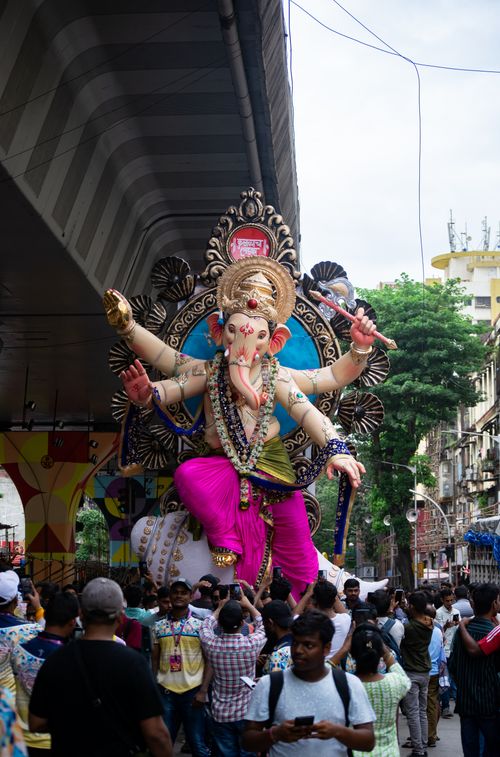 Free A vibrant crowd celebrates Ganesh Chaturthi with a grand idol procession in Mumbai. Stock Photo