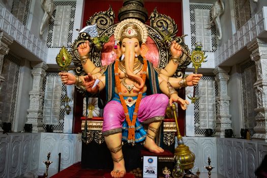 A beautifully adorned Ganesh idol at a temple in Mumbai during Ganesh Chaturthi, showcasing vibrant colors and intricate design.