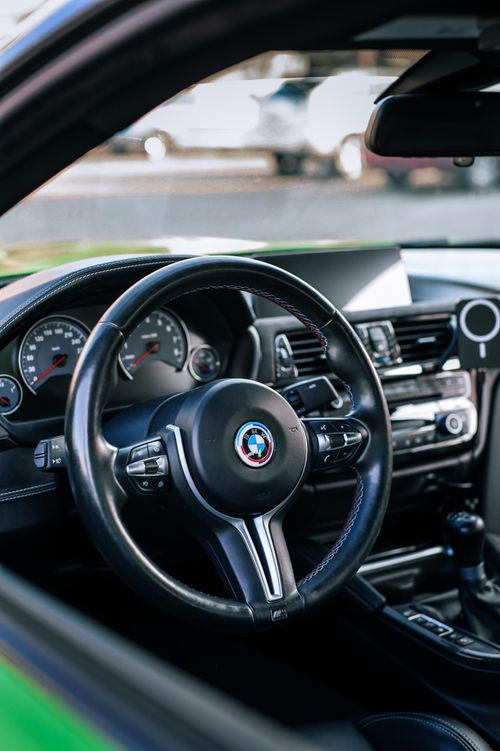Free Close-up of a luxury car's steering wheel and dashboard showcasing elegant design. Stock Photo