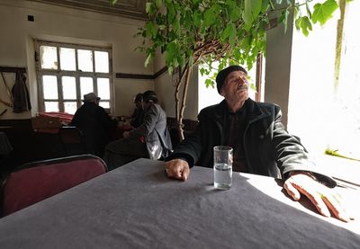 An elderly man by a sunlit window in Trabzon, Türkiye