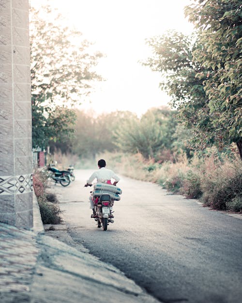 Man Riding a Motorbike down a Road
