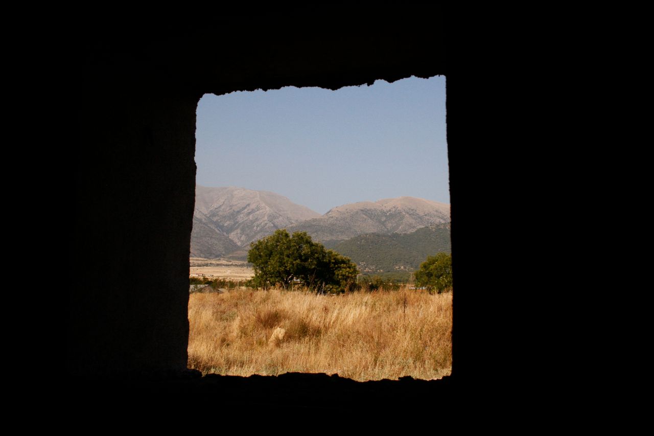 serene countryside view of serres greece seen through a window frame