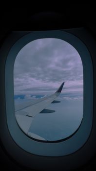 View from an airplane window showing the wing and a cloudy sky, capturing the essence of modern travel.