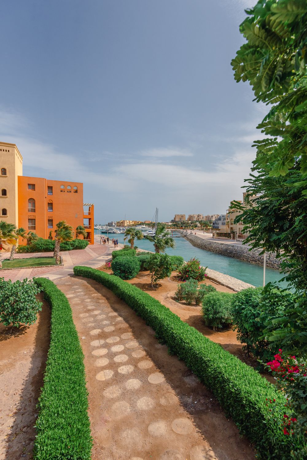 Grüner Resortweg mit Palmen entlang eines Kanals bei Hurghada
