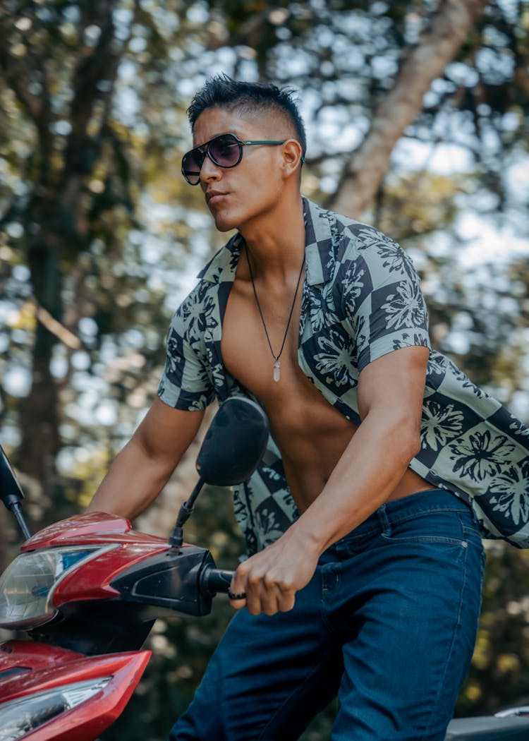 Young Man In Unbuttoned Shirt Riding A Motorbike 