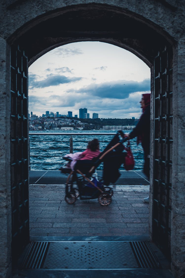 Parent Walking With Child In Stroller On Sea Shore In Istanbul