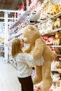 Woman Carrying Bear Plush Toy Inside Store