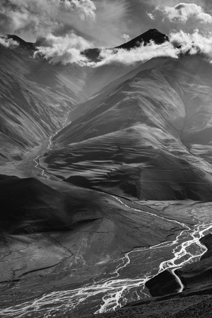 Breathtaking black and white mountain landscape with glaciers and cloud cover.