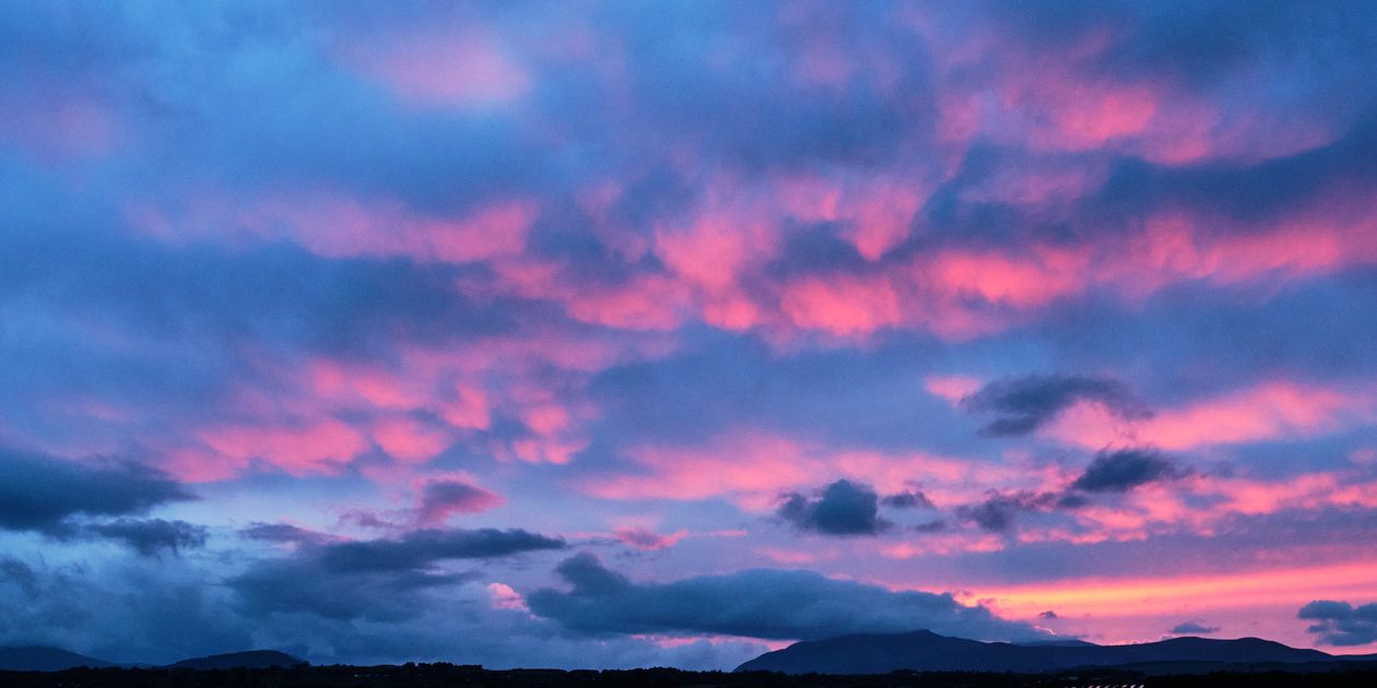 A colorful sunset over the mountains and clouds · Free Stock Photo