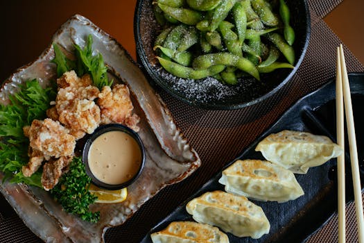 Delicious Asian dishes including dumplings, fried chicken, and edamame, perfect for a savory dining experience.