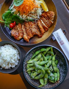 日本餐的顶视图特色是烤鸡、米饭和毛豆