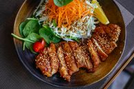 美味的鸡肉沙拉碗上，装饰着芝麻、新鲜蔬菜和柠檬角