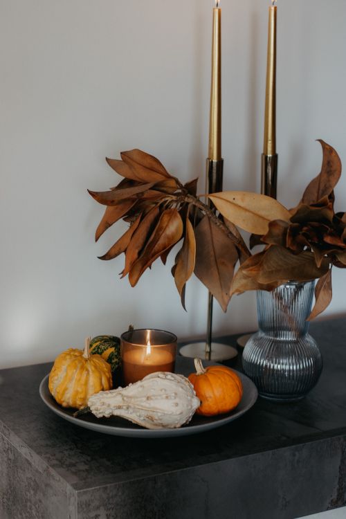 Free Elegant autumn arrangement with pumpkins, candle, and leaves in a vase. Stock Photo
