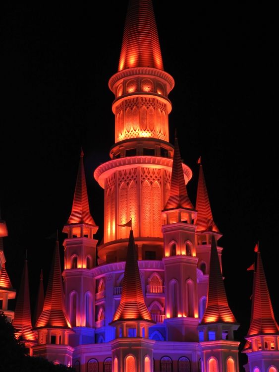 A brightly lit castle tower at night, used as a stock illustration