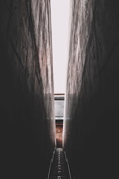 这张戏剧性的镜头拍摄了一条狭窄通道，楼梯位于高耸的墙壁之间