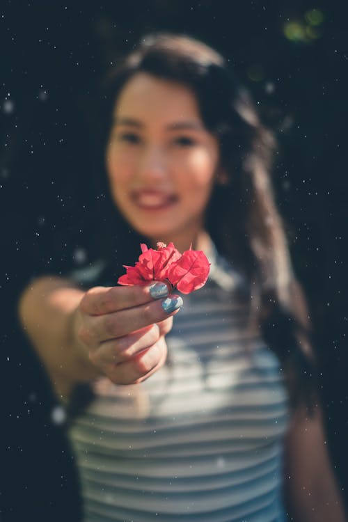 Женщина, держащая цветок бугенвиллии