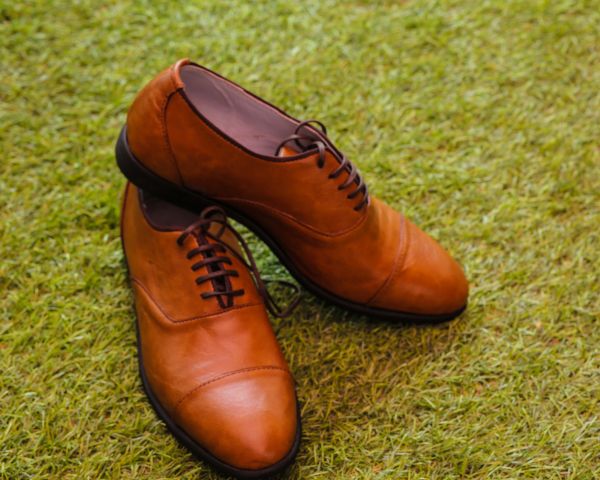 Brown leather boat shoes on grass