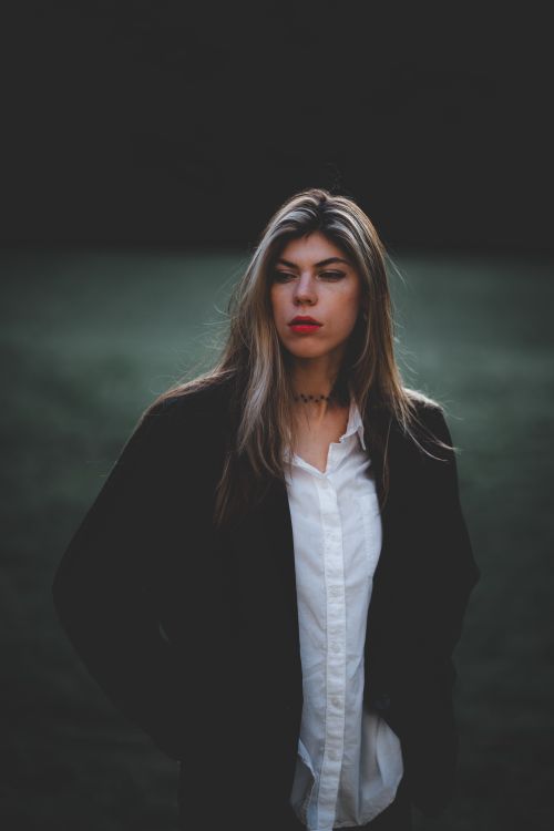 Free Fashionable woman in a black jacket outdoors with minimalistic background. Stock Photo