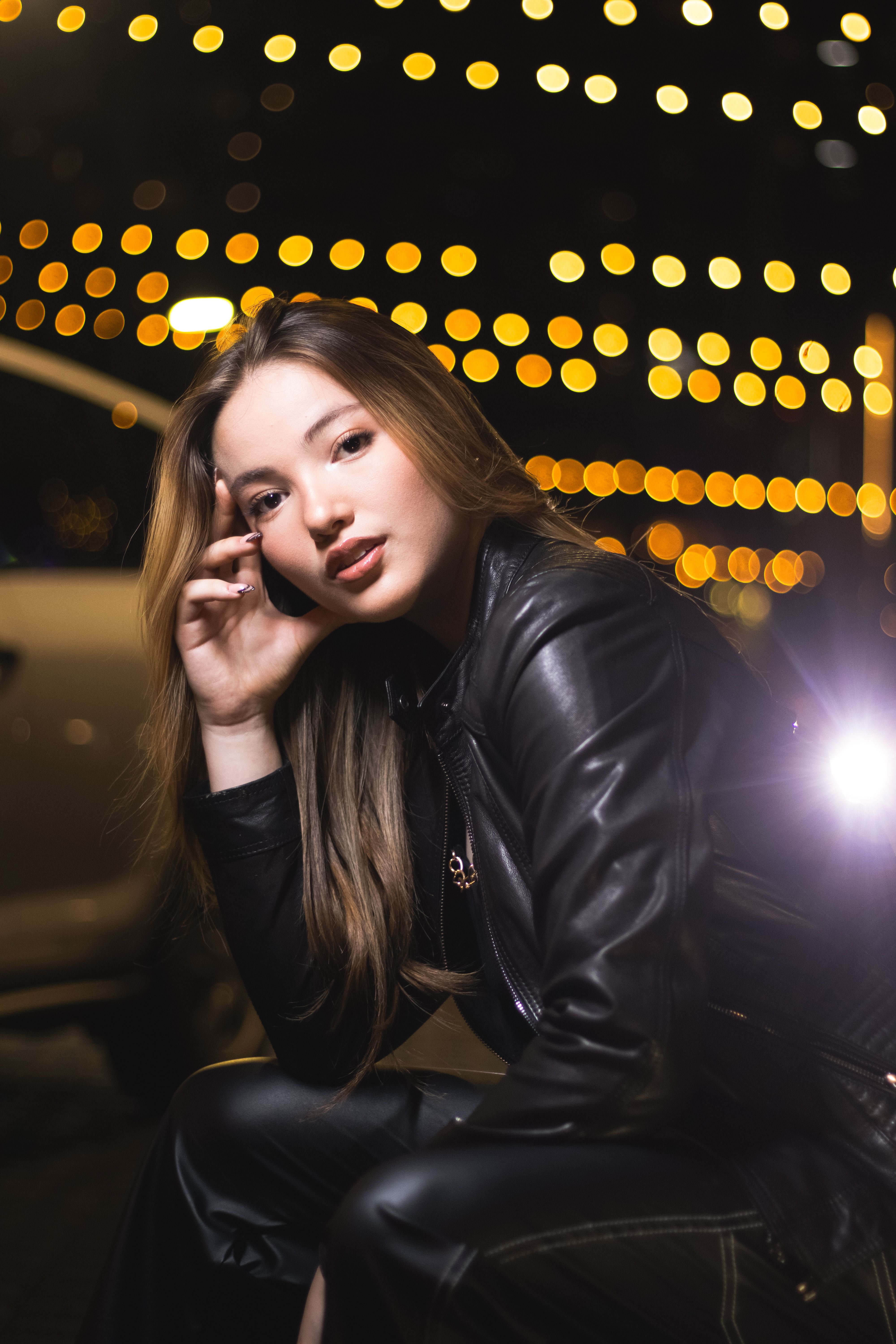 A woman in leather jacket sitting on the ground · Free Stock Photo