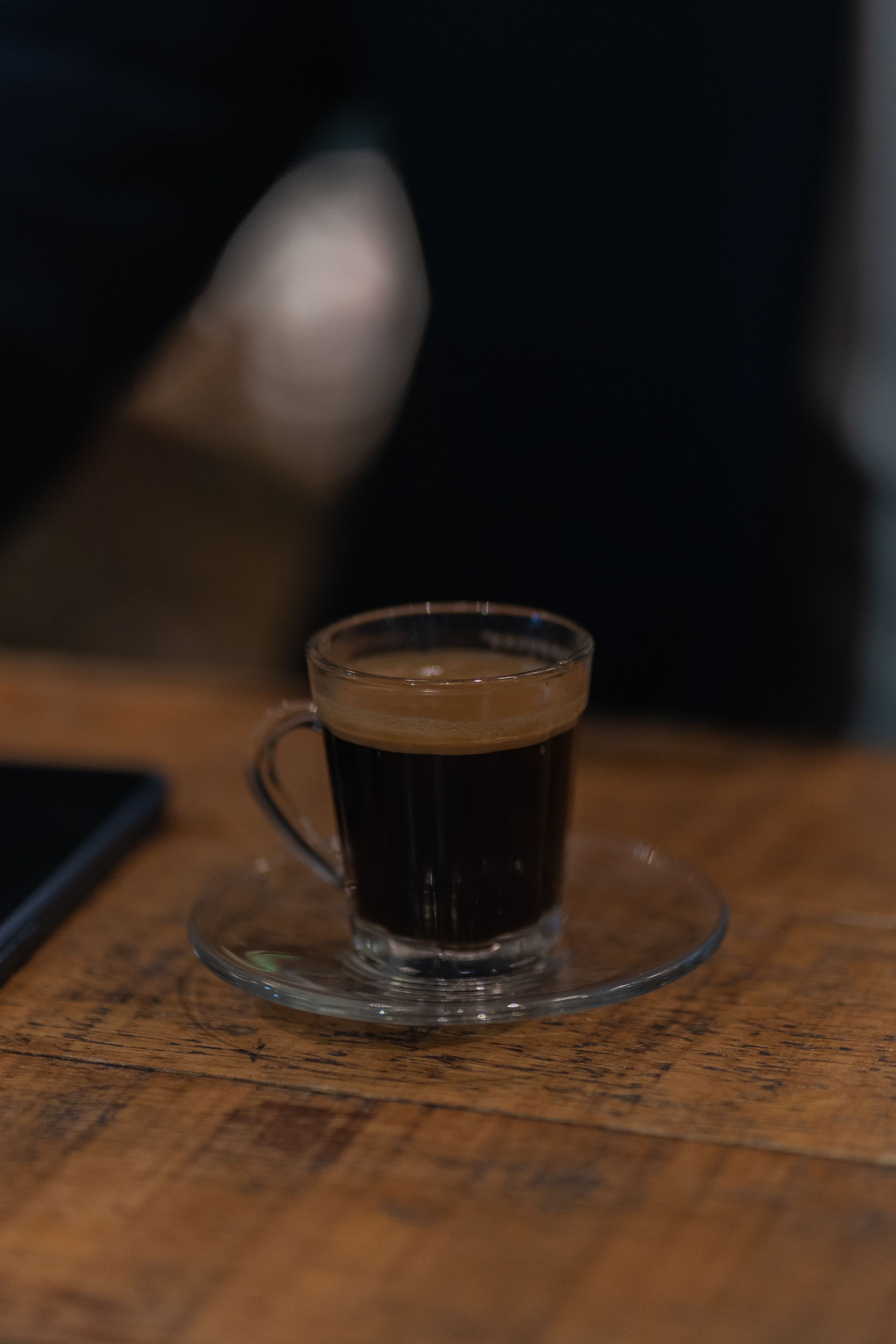 A warm espresso on the wooden counter
