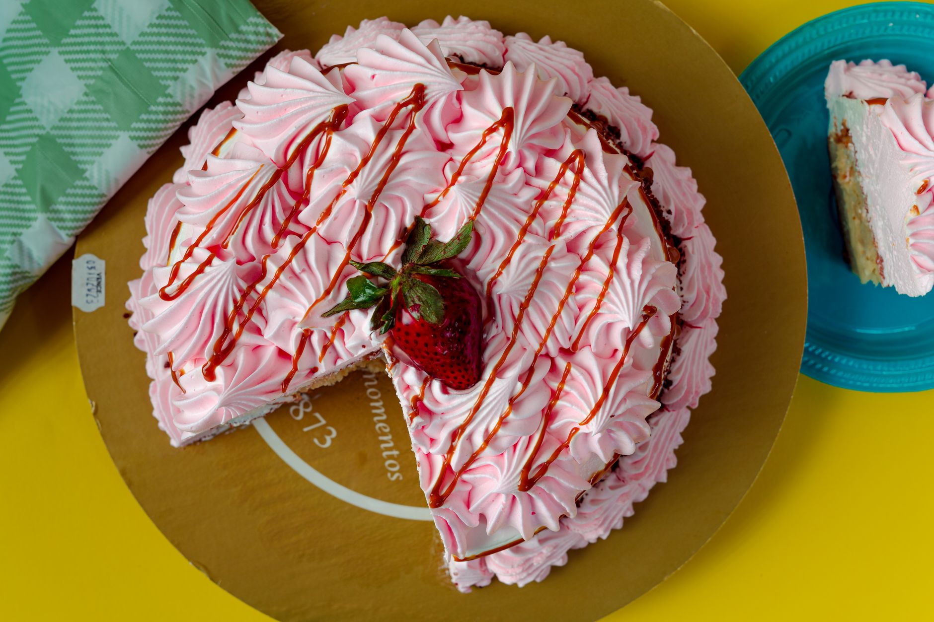 Slice of strawberry ice cream cake with crumbs on plate