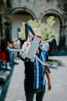 Person holding a drone in a courtyard in Guadalajara, Mexico.