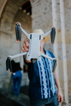 Close-up of a man holding a drone in a city environment, showcasing modern technology.