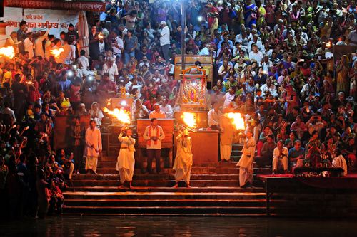 Free A vibrant crowd attends a Hindu Aarti ritual on the riverbanks, showcasing cultural traditions. Stock Photo