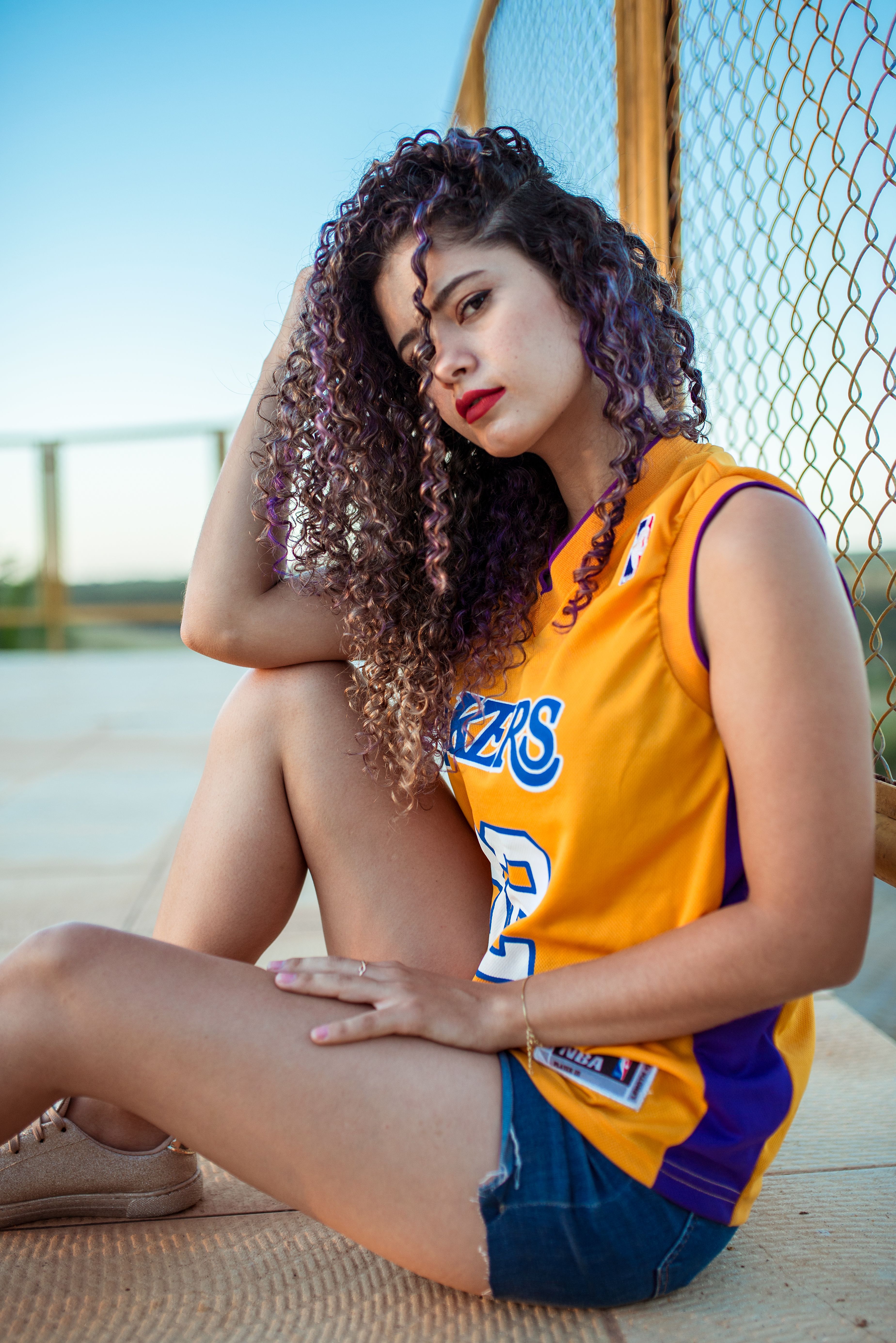 Casually dressed woman sitting on the ground outdoors, exuding a relaxed and stylish vibe.