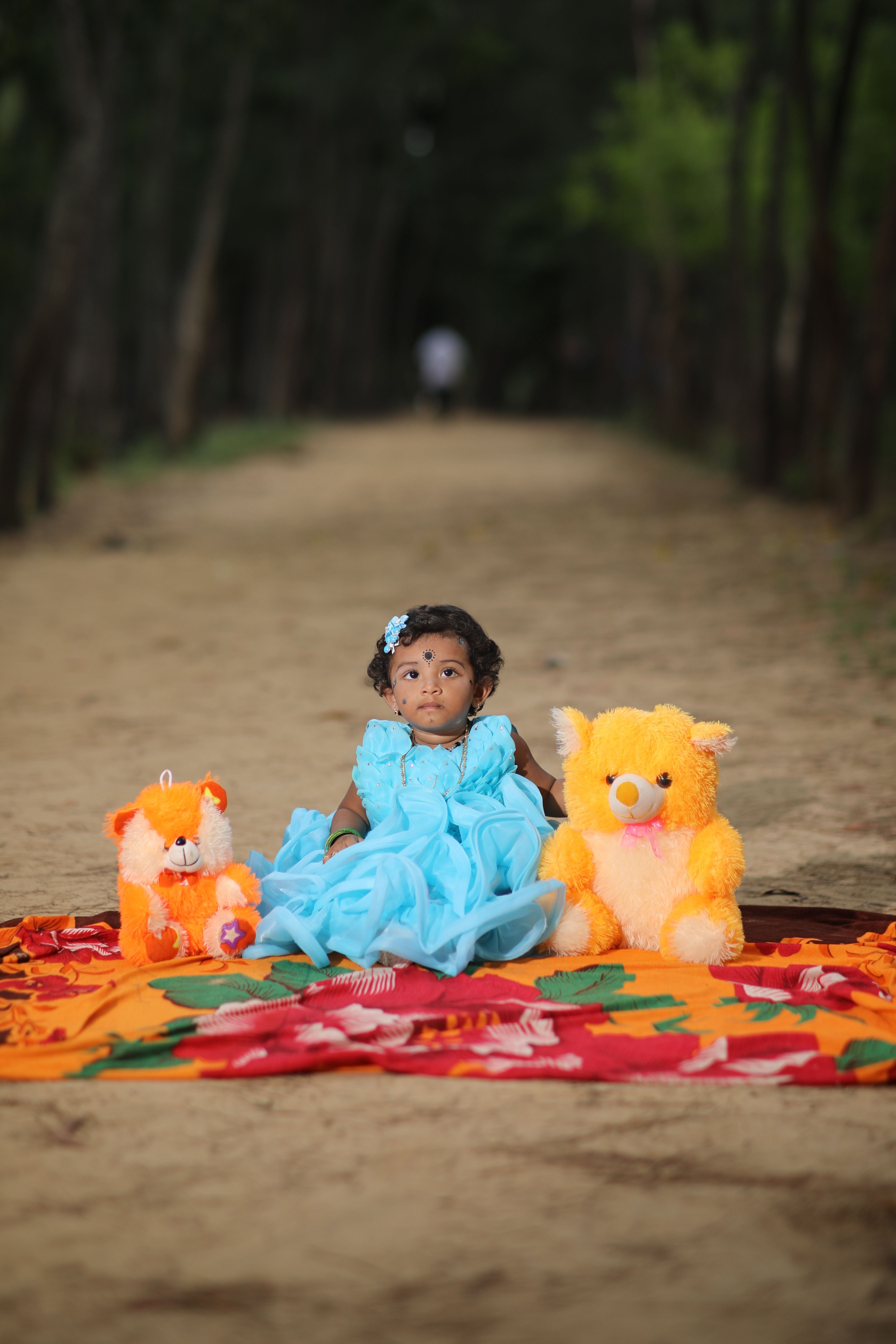 Little Girl in an Elegant Blue Dress Sitting with Plushies on a Blanket ...