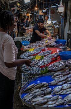 Discover the vibrant atmosphere of a traditional fish market in İzmir, Türkiye, showcasing fresh seafood and lively interactions.