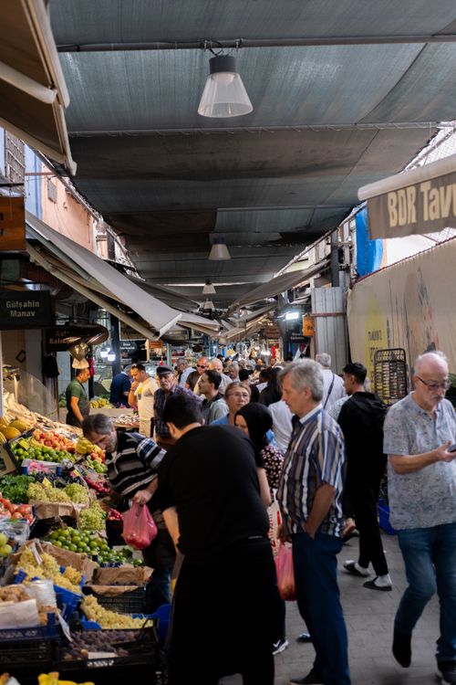 Free Crowded street market in Turkey with diverse people shopping for fresh produce under a typical covered arcade. Stock Photo