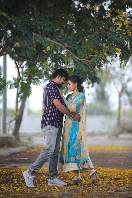 Woman in Dress and Man in Shirt Embracing