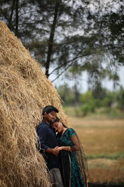 Couple Hugging by Hay Bale