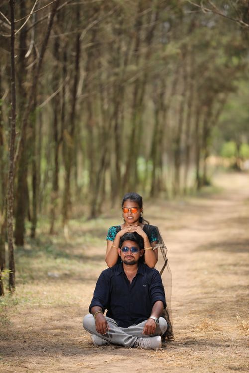 Free Couple posing playfully in a serene forest setting, exuding happiness and connection. Stock Photo