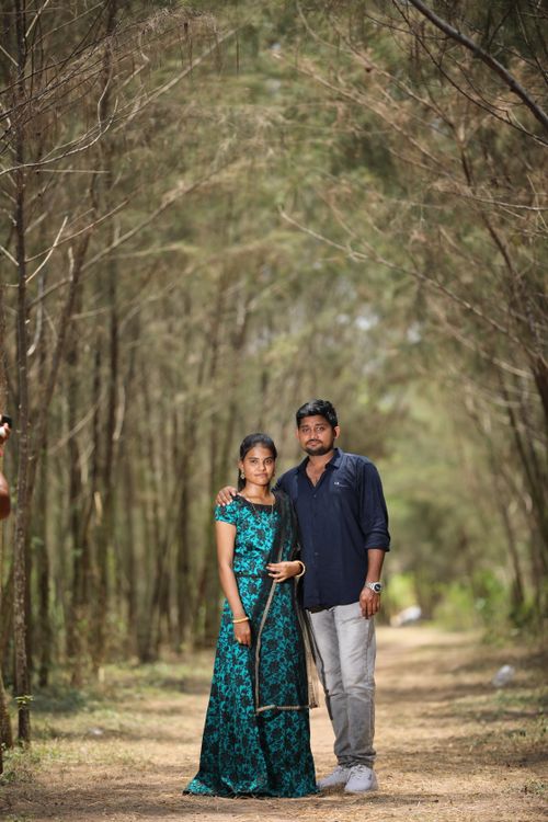 Free A couple poses together, creating a warm moment on a tranquil forest path. Stock Photo