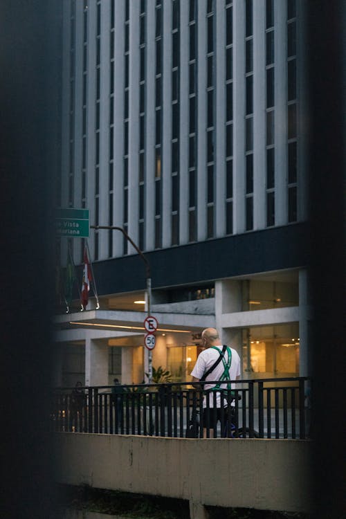 Man In White T Shirt Walking On Sidewalk