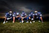 Free Football Players in Blue Jersey Lined Under Grey White Cloudy Sky during Sunset Stock Photo