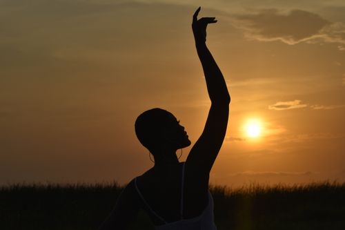 Free Graceful silhouette of a woman dancing against a vibrant sunset in Accra, Ghana. Captures elegance. Stock Photo