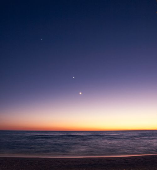 Free Stunning coastal sunset at Torrenueva, Spain, showcasing a crescent moon over tranquil sea waves. Stock Photo