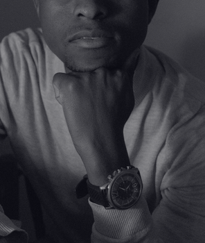 Elegant black and white portrait highlighting a man's wristwatch.