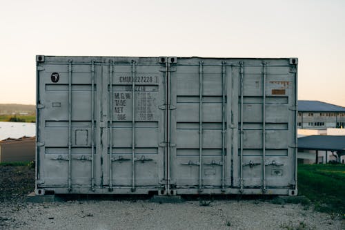 Two white shipping containers sitting on top of each other