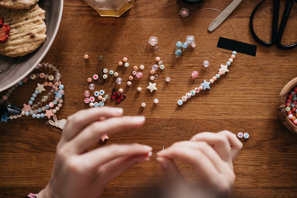 Hands personalising charms at the Co-Creation table — photo by Lisett Kruusimae on Pexels