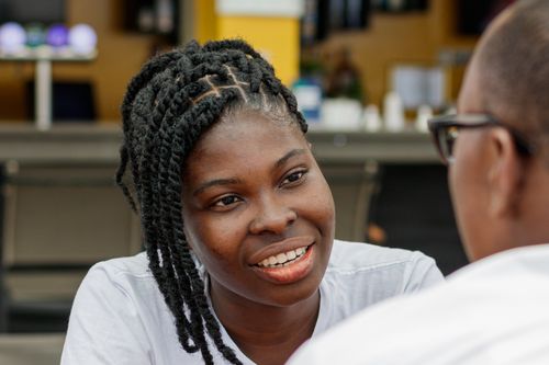 Free Two people engaging in a conversation at an outdoor cafe in Accra, Ghana. Stock Photo