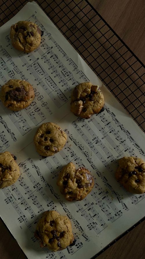 Free Delicious homemade chocolate chip cookies displayed on music sheets. Stock Photo
