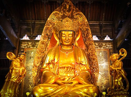 Free Magnificent golden Buddha statue inside a traditional temple, radiating spirituality and peace. Stock Photo