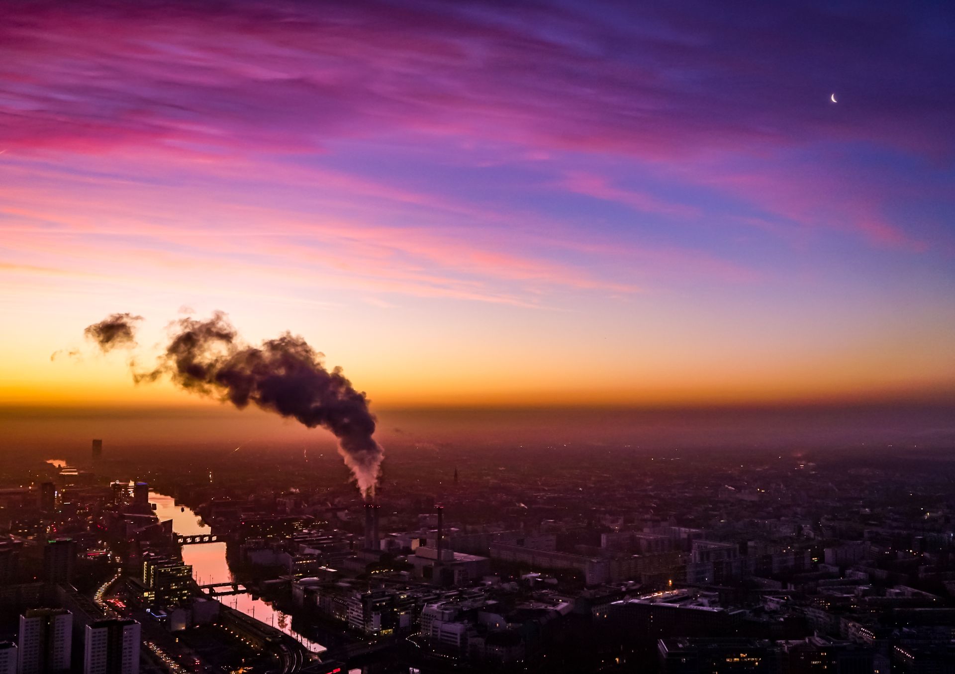 Stunning aerial view of Berlin at sunset with vibrant colors and factory smoke.