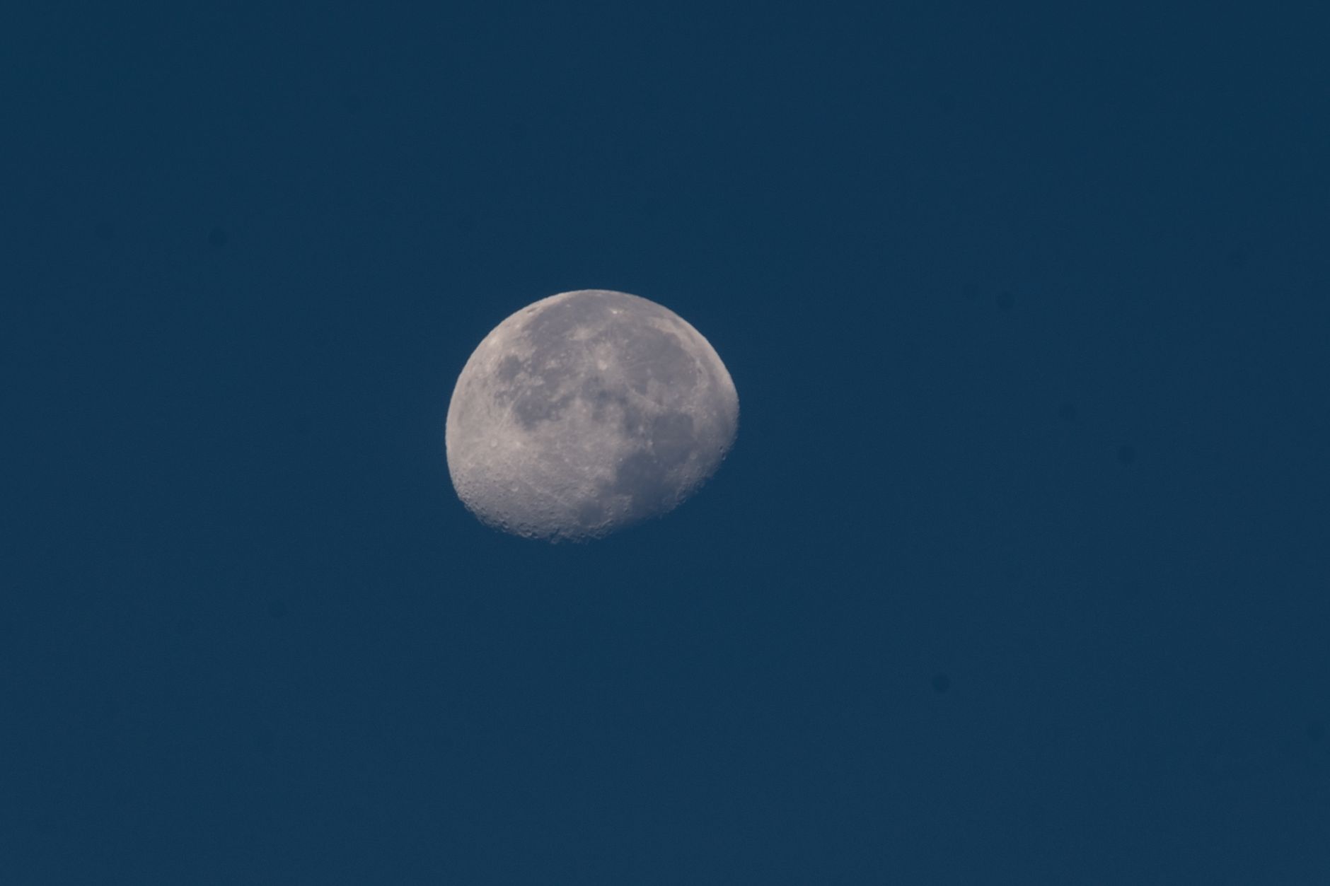 Crescent moon captured in a serene twilight sky, highlighting lunar details.