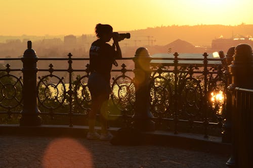 Photographer Taking Photo of Sunset in City