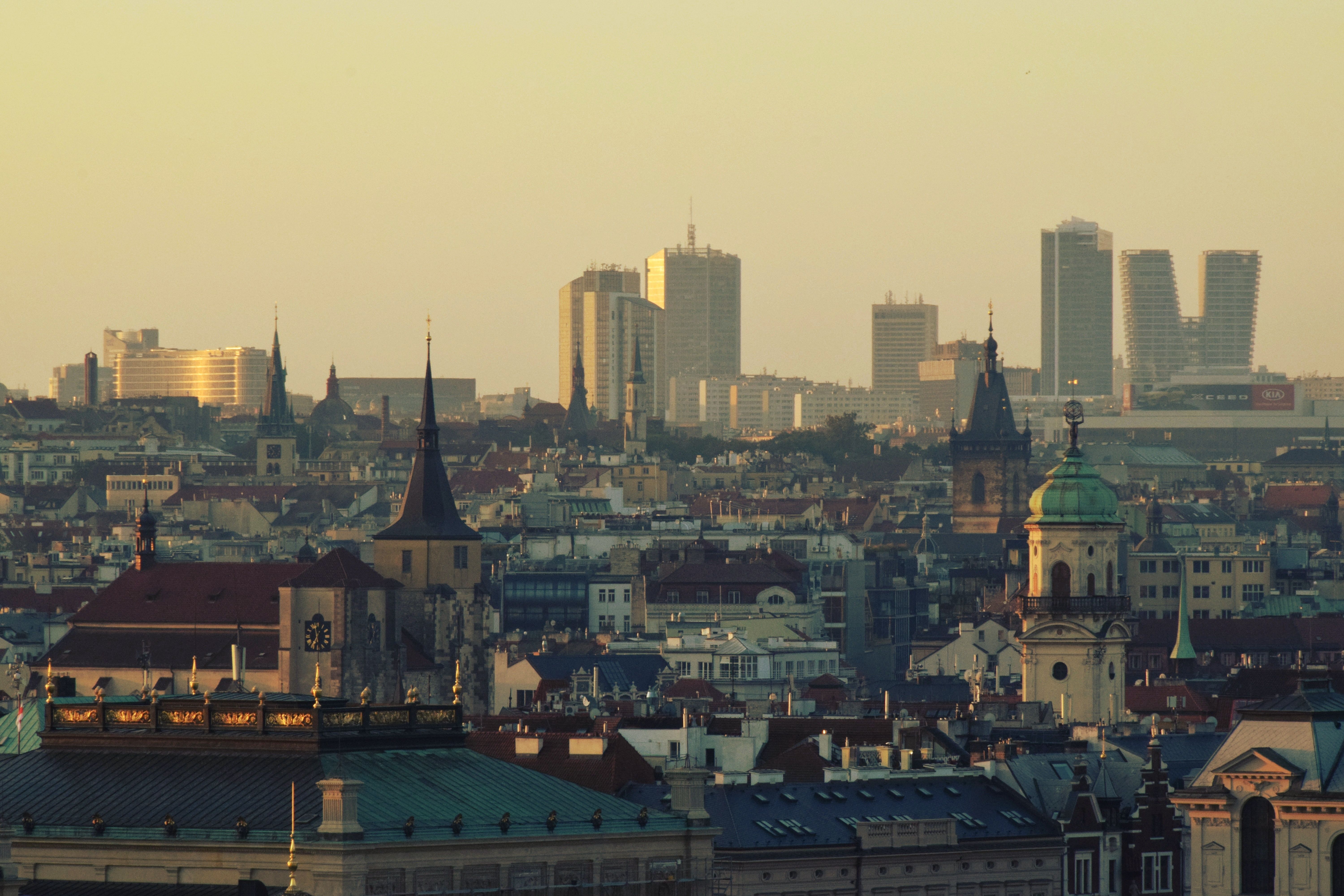 Panoramic view of Prague in the Czech Republic combining historic rooftops with the modern business district skyline at dawn